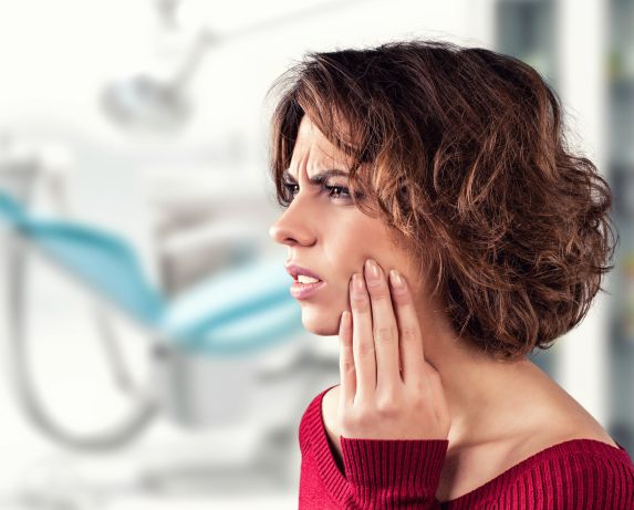 Young woman with dental pain at a dentist's office